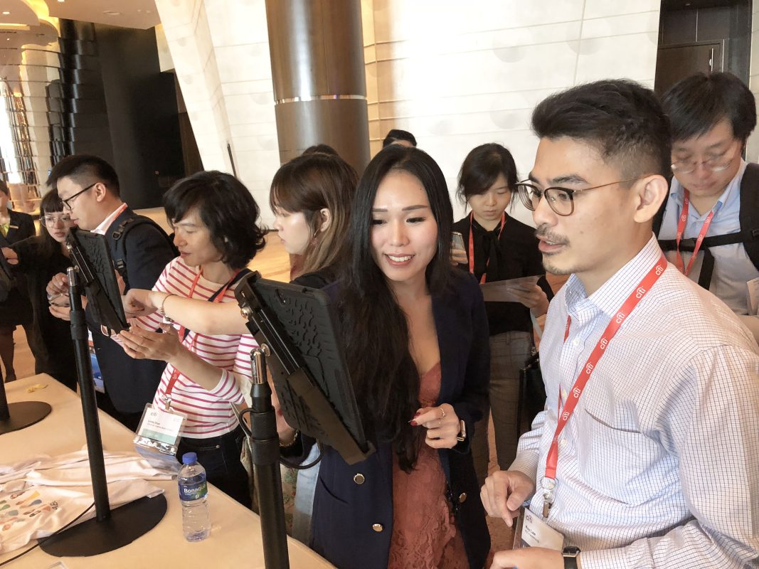 Attendees at an event engaging with digital screens to create personalized products, showcasing the power of personalization in games for Dinner and Dance events. The interaction highlights how customized experiences can enhance engagement and create lasting memories for participants.