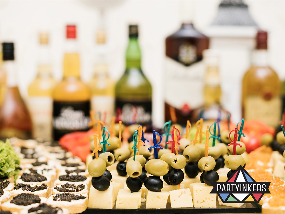 Close-up of gourmet appetizers and assorted drinks, showcasing the variety of unique food and beverage options available at a launch party.