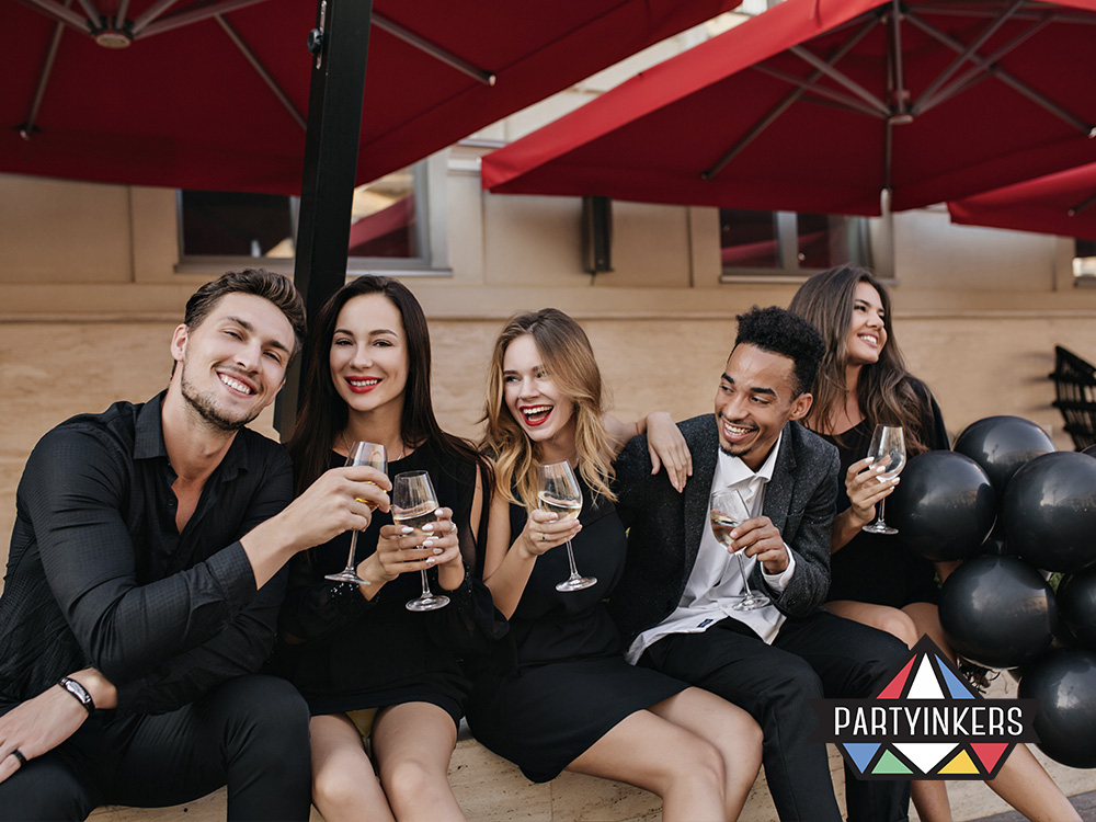 Group of elegantly dressed people enjoying a VIP experience with drinks and celebration, highlighting the value of offering exclusive experiences for key guests at a product reveal.