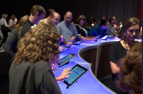 A group of attendees engaging in an interactive trivia game on tablets at an event. This image represents the 'Interactive Trivia with Custom Prizes' section, where participants can compete in real-time quizzes and win personalized prizes, adding excitement and engagement to the Dinner and Dance event.