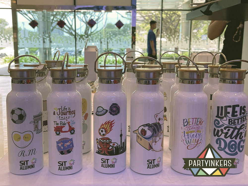 A collection of personalized bamboo lid thermo flasks with colorful custom designs and names as conference gifts for attendees, created for attendees at the SIT ICG event using Partyinkers' live engraving service
