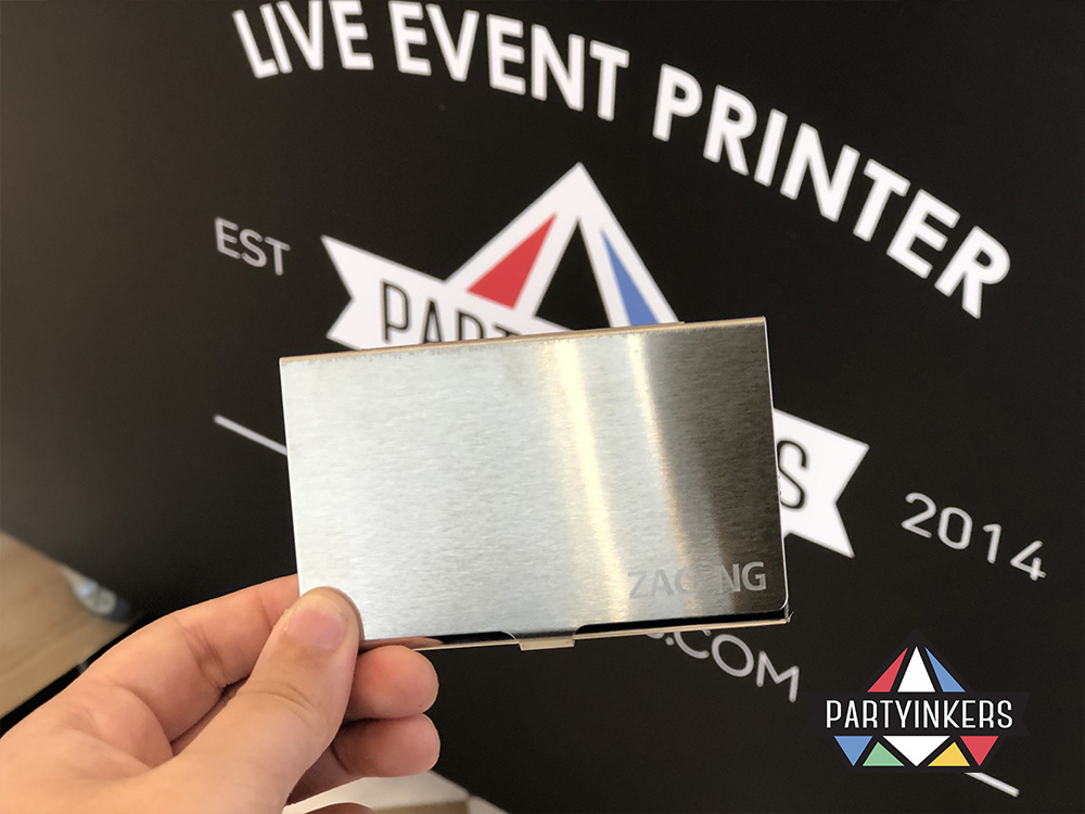 A close-up of a personalized engraved metal card holder featuring a sleek design as conference gifts for attendees, created using Partyinkers' live laser engraving service at an event.