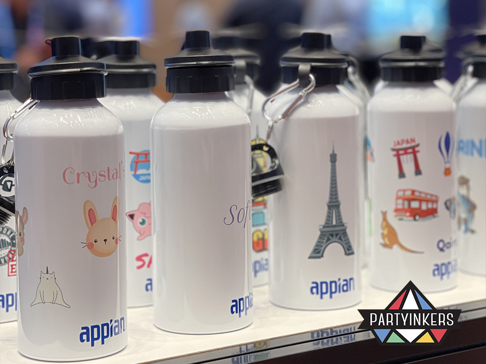 A row of personalized aluminum bottles featuring various custom designs and names, created as conference gifts for attendees at a conference using Partyinkers' live digital printing service.