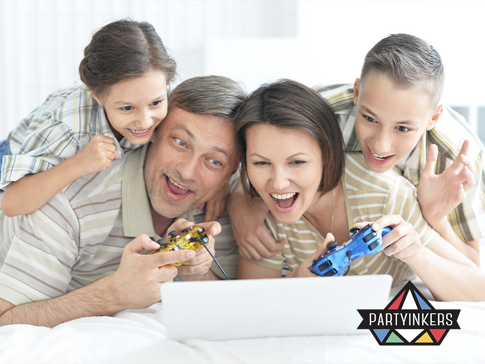 A family of four excitedly playing virtual games together on a laptop during a corporate family day activities