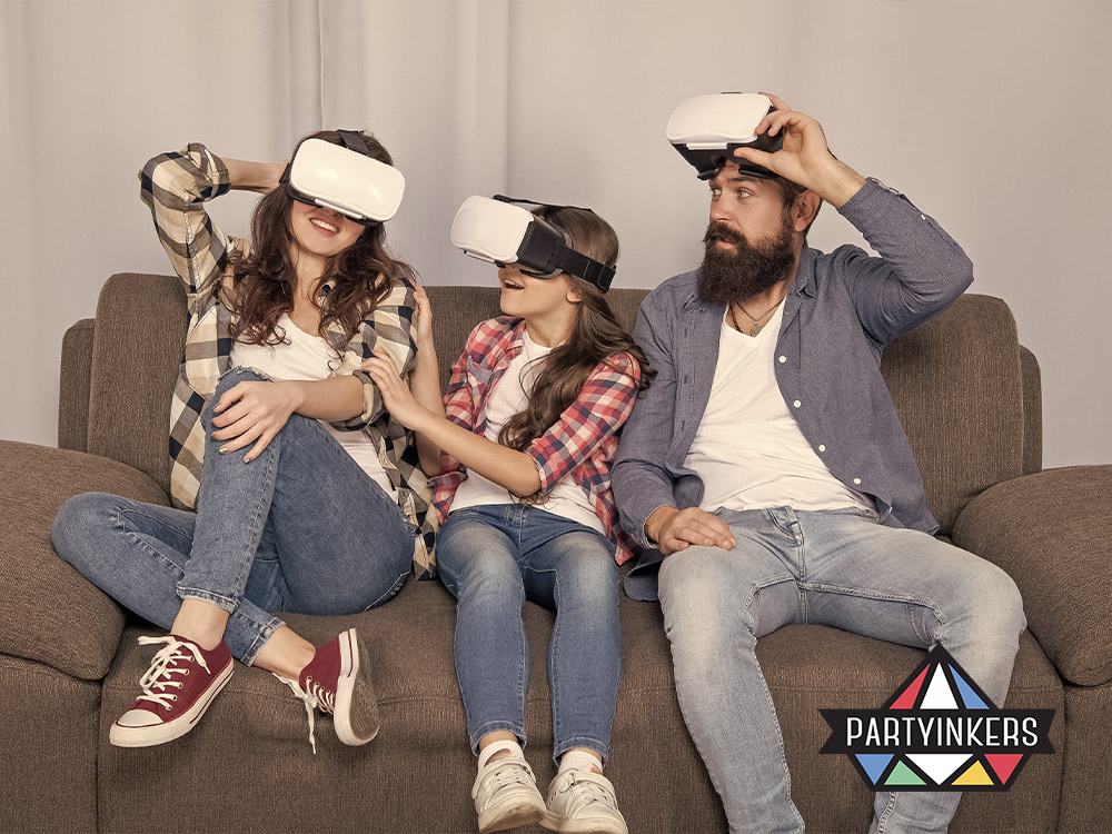 A family of three sitting on a couch and enjoying a virtual reality experience together at a corporate family day activities, with VR headsets on.
