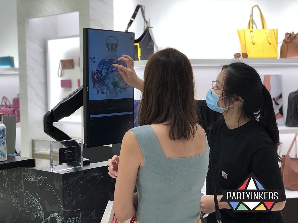 An attendee using a touchscreen to design a personalized item at an event, highlighting how technology can enhance engagement by offering interactive and immersive experiences through real-time customization.