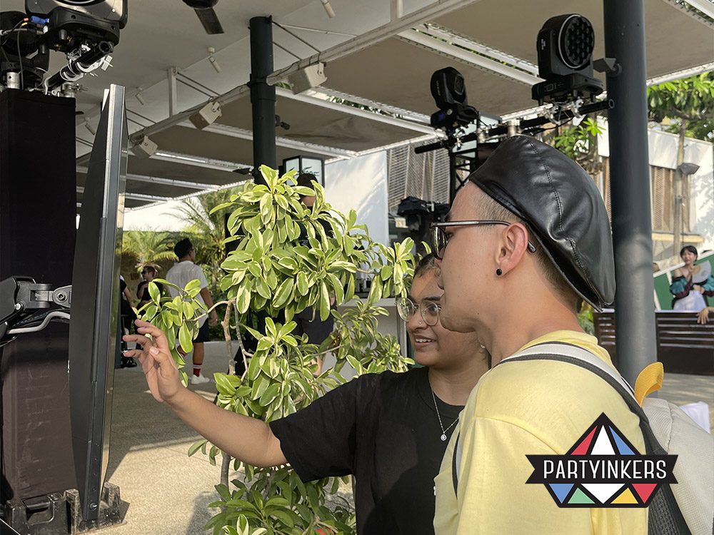 Two attendees interact with a touchscreen at an event, engaging with a digital interface at a Partyinkers booth. The use of technology showcases how event engagement can be enhanced through interactive and personalized experiences.