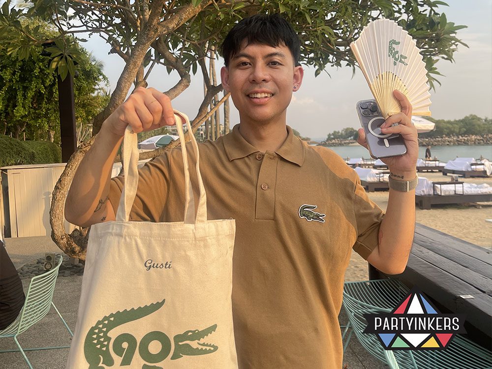 One attendees hold up their personalized tote bags featuring custom designs created at a Partyinkers interactive booth during an event. The personalized products highlight how event engagement can be enhanced through interactive and memorable activities.