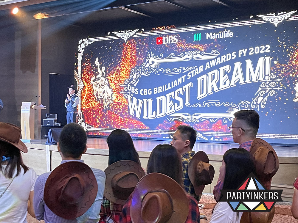 Guests at a gala dinner event enjoying the awards ceremony entertainment with a Western-themed stage backdrop, showcasing creative award presentations and interactive gala dinner event activities.