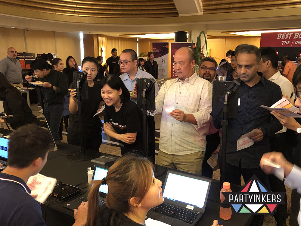 Attendees at a Partyinkers event eagerly engaging with the laser engraving station, watching as their custom designs are engraved onto products in real-time, showcasing the innovative and interactive nature of laser engraving as a booth idea