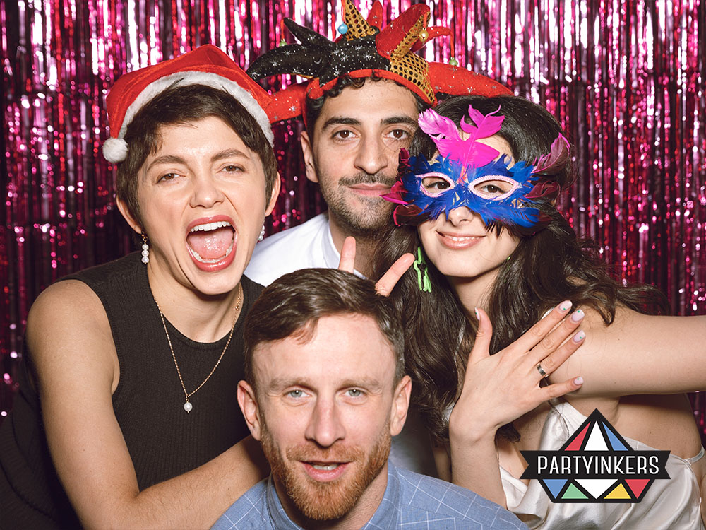 A group of attendees having fun in a photo booth with festive props and a colorful backdrop, capturing shareable moments and highlighting the appeal of photo booths as interactive booth ideas at events.