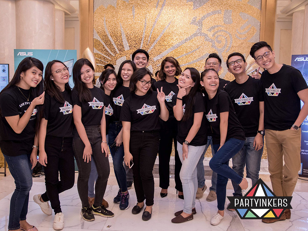 Partyinkers team sets up live digital printing stations where attendees design and print customized tote bags, T-shirts, or other merchandise on the spot