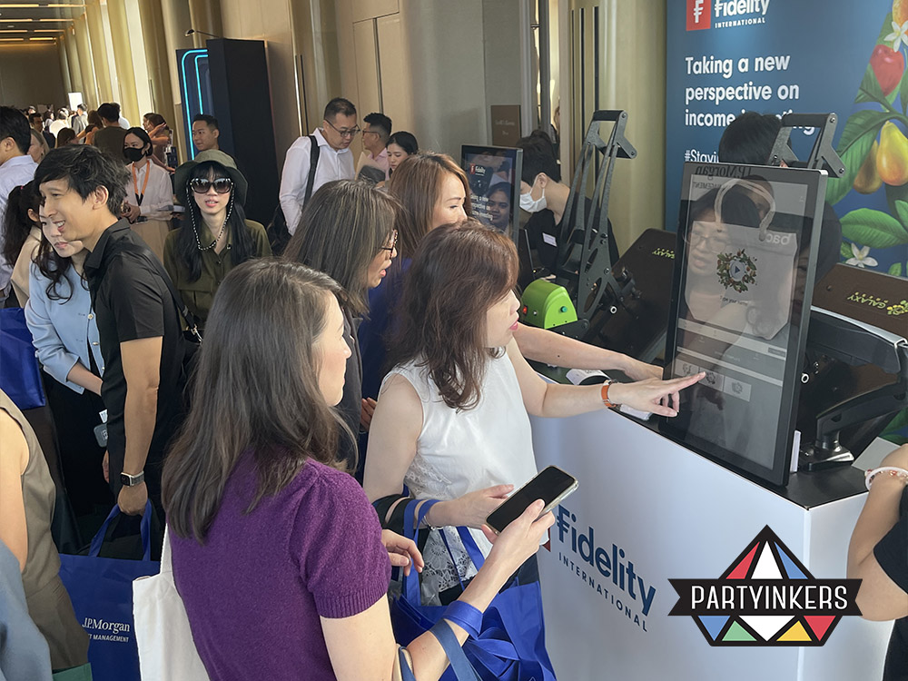 Attendees engaging with Partyinkers’ live printing booth at a trade show. The interactive booth allows visitors to customize their own tote bags, showcasing Partyinkers’ innovative live personalization services that enhance the trade show experience by drawing crowds and encouraging participation.