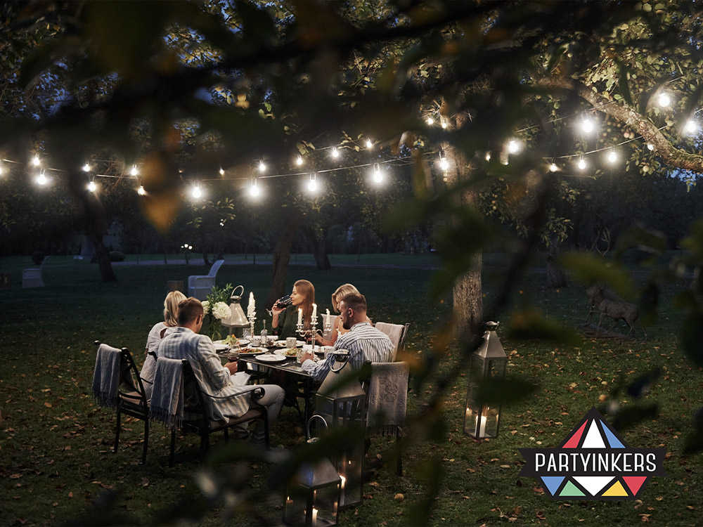 An enchanting outdoor Dinner and Dance theme featuring string lights, elegant table settings, and a cozy atmosphere, perfect for a magical evening event.
