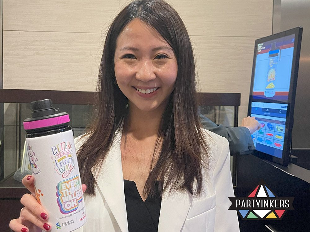 A guest at a Dinner and Dance theme event showcasing a customized water bottle designed at a live printing station, highlighting interactive and personalized event experiences.