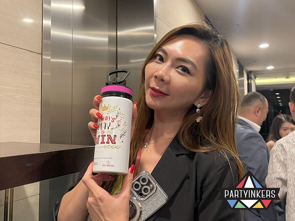 A guest at a Dinner and Dance theme event showcasing a customized water bottle designed at a live printing station, highlighting interactive and personalized event experiences.