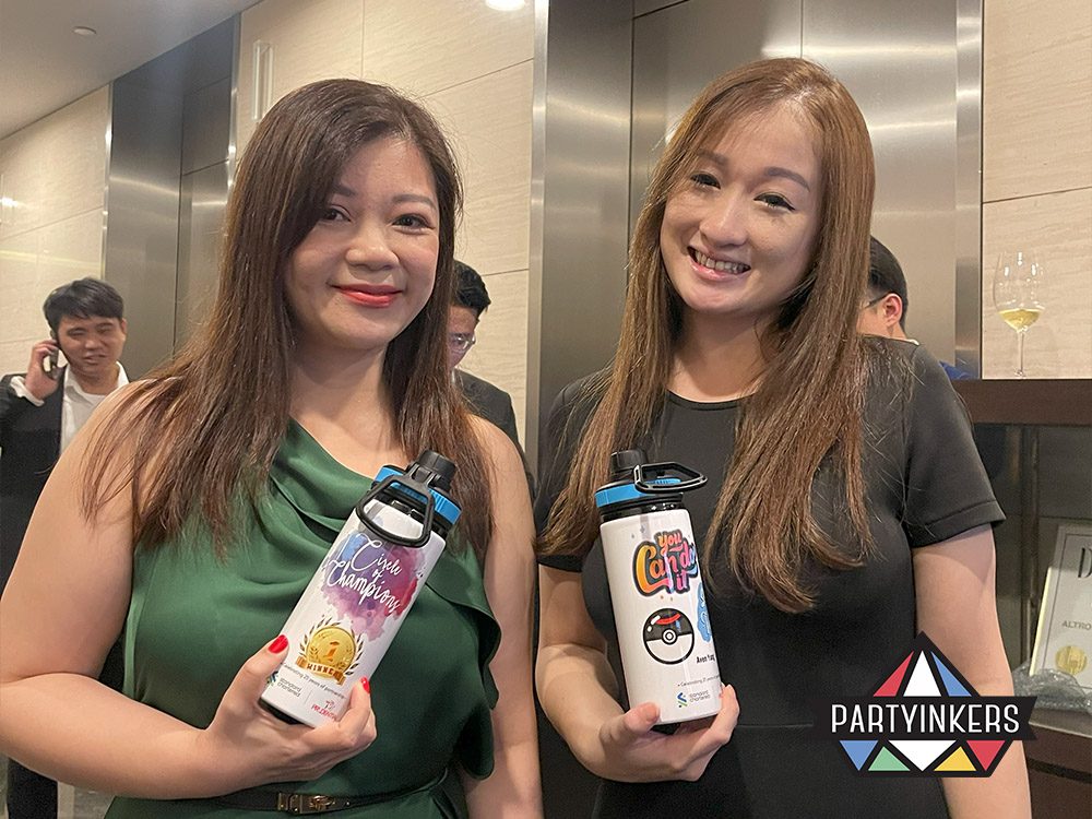 A guest at a Dinner and Dance theme event showcasing a customized water bottle designed at a live printing station, highlighting interactive and personalized event experiences.