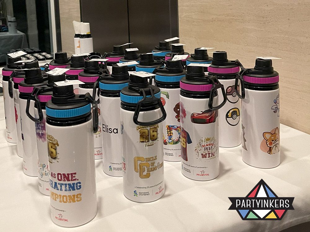 Customized water bottles displayed at a Dinner and Dance theme event, featuring unique designs created at a live printing station, adding a personalized touch to the celebration.
