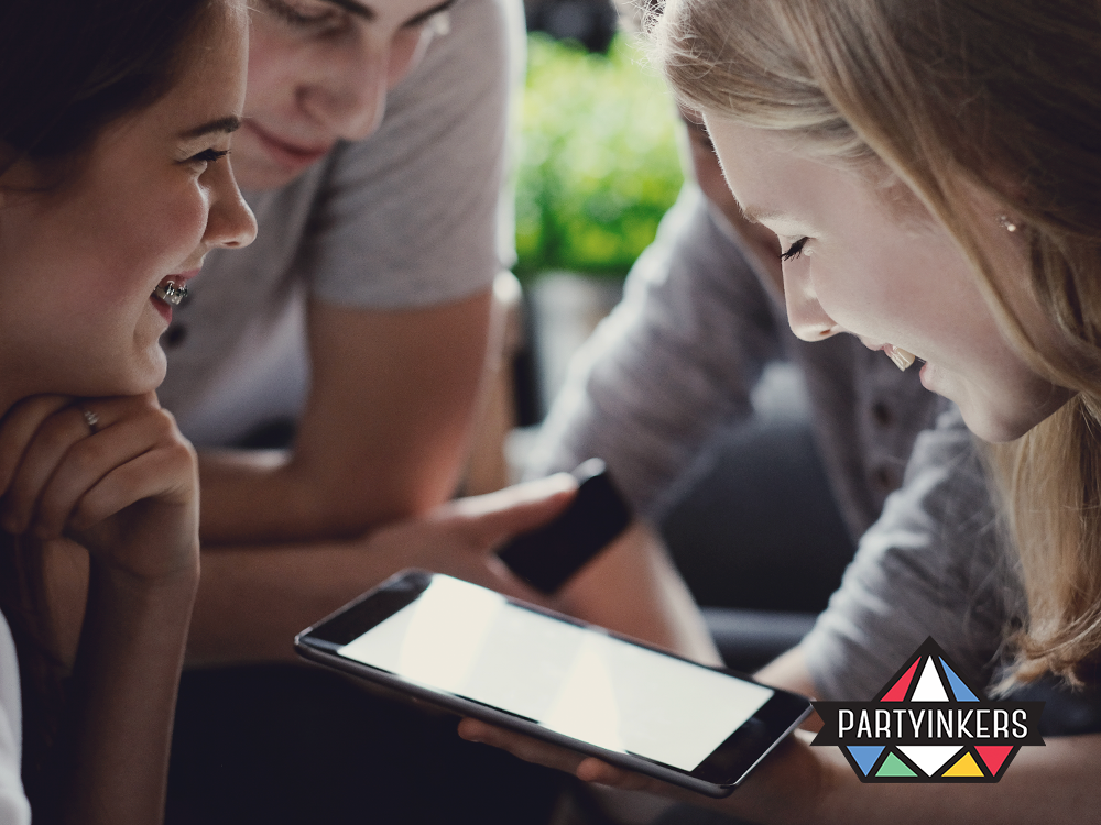 A group of young professionals engaging with a digital tablet, representing connectivity and interactive technology in corporate events.