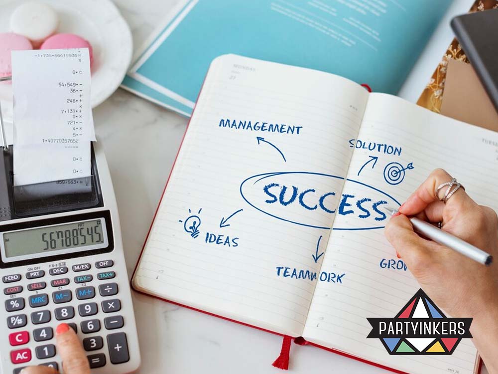 A close-up of a desk setup featuring a notebook with the word 'SUCCESS' written in the center, surrounded by related terms like 'ideas,' 'teamwork,' 'management,' 'solution,' and 'growth.' A calculator and handwritten receipts are nearby, symbolizing planning and goal-setting and measuring succes.