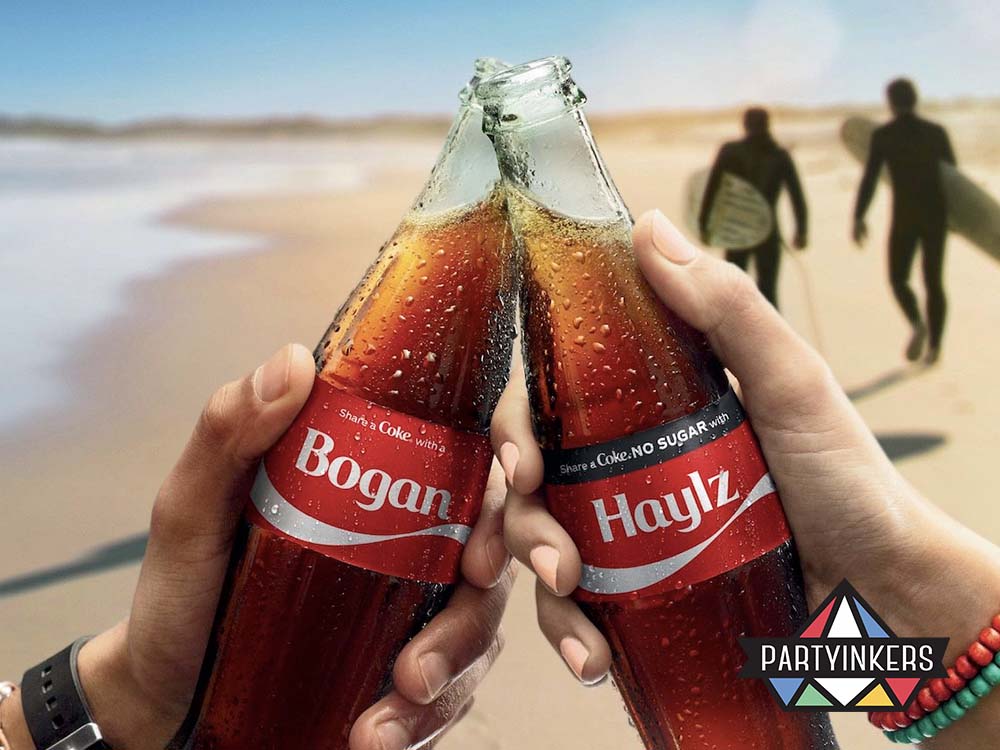 Two hands holding personalized Coca-Cola bottles in a celebratory toast against a beach backdrop. This creative brand activation idea uses customized products to create emotional connections with customers.