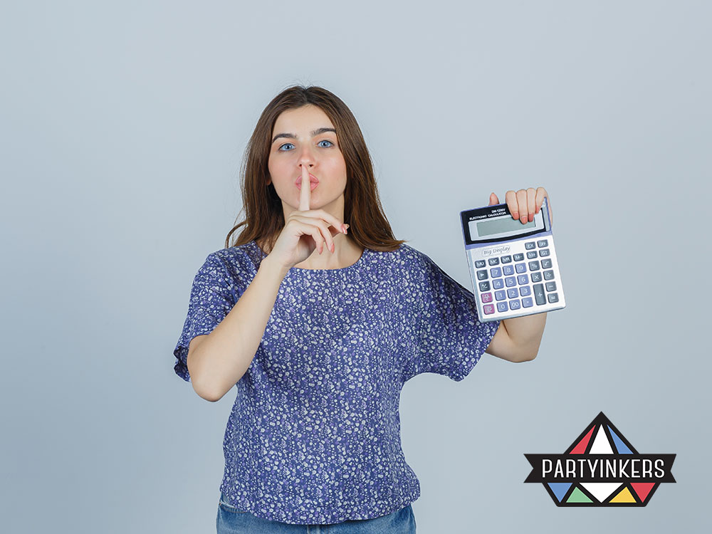 A woman in a casual outfit holding a large calculator and making a shushing gesture, conveying the idea of importance of checking about hidden cost.