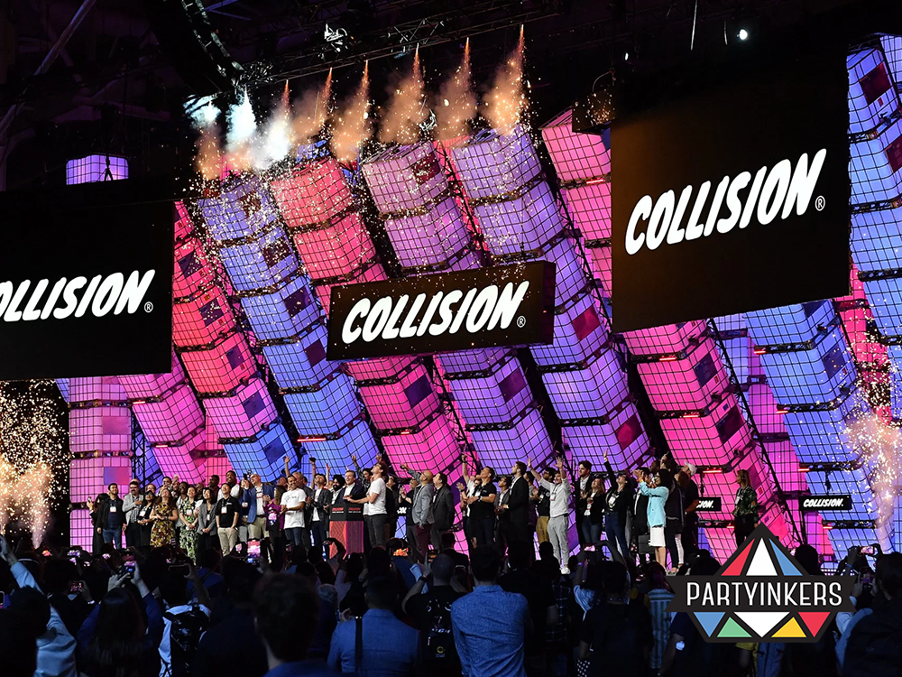 Energetic closing celebration at the Collision Conference with vibrant lights and an engaged audience, highlighting creative conference entertainment ideas.