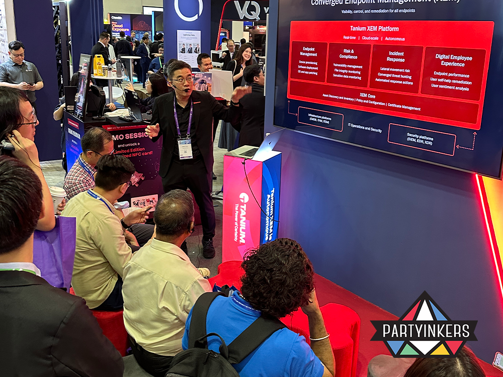 "An engaging presentation at a trade show booth, showcasing the Tanium XEM Platform to a seated audience. The interactive session highlights endpoint management, risk and compliance, and digital employee experience, with attendees actively participating and learning."







