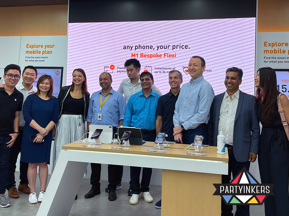 A group of executives and brand representatives stands together at the M1 Bespoke Flexi product launch event. This is a strong brand activation idea that reinforces corporate engagement and brand loyalty