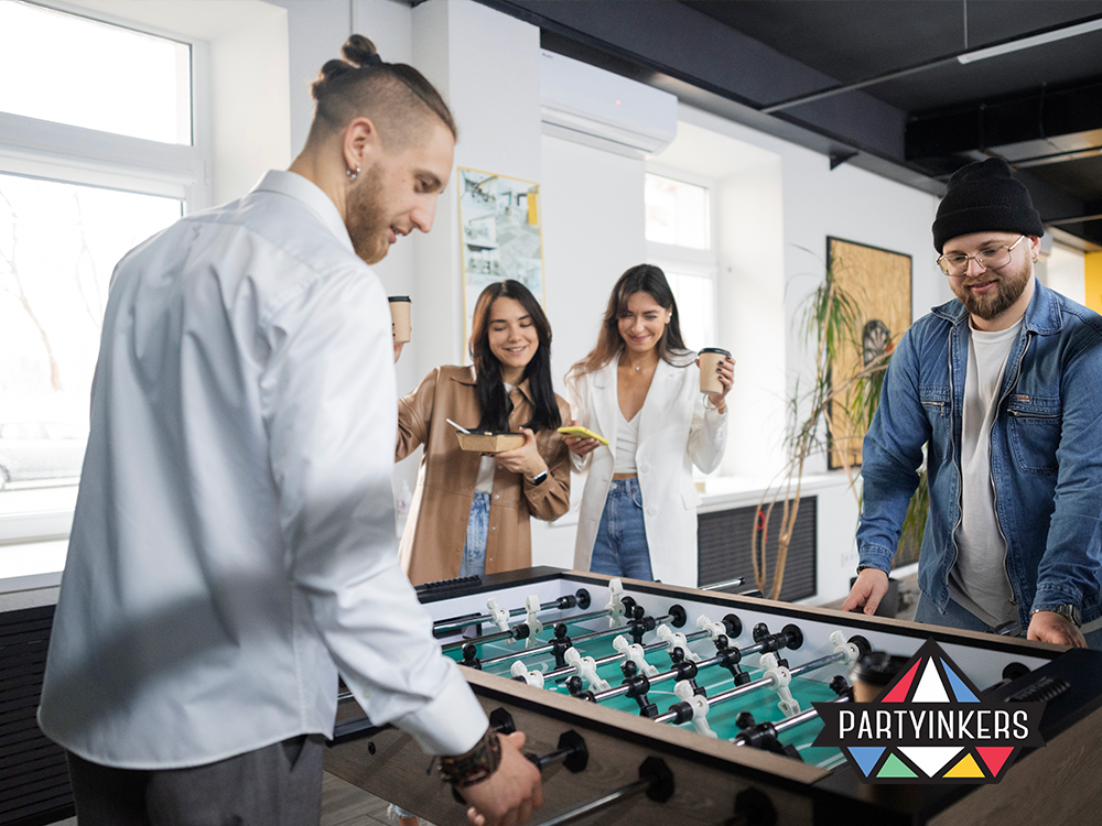 "A casual office setting where colleagues enjoy a friendly foosball match, promoting team bonding and a fun workplace environment."