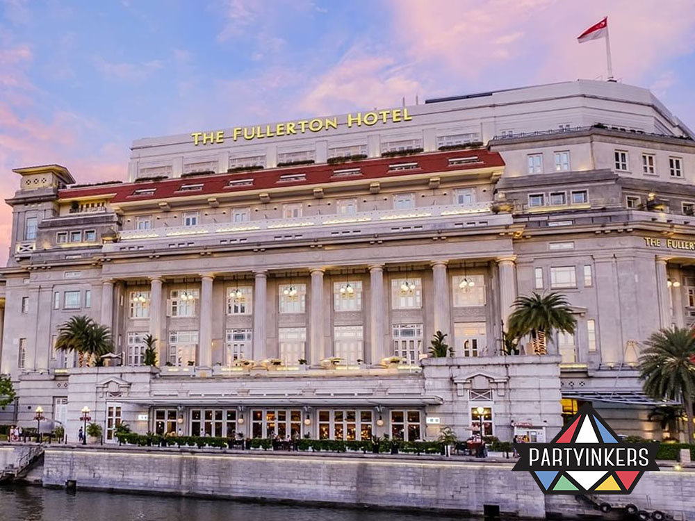 The majestic Fullerton Hotel in Singapore, illuminated under a pastel sunset, showcasing its grand colonial architecture along the riverside.