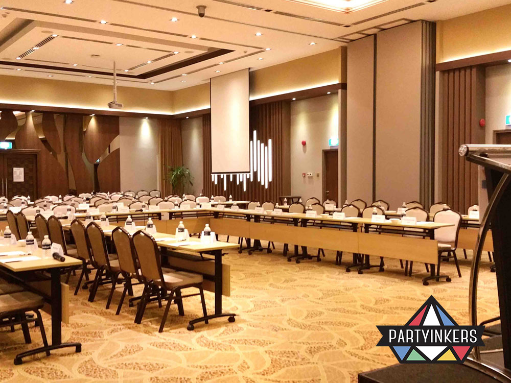 A spacious and modern conference room setup with rows of tables and chairs, ready to host a corporate meeting or seminar.