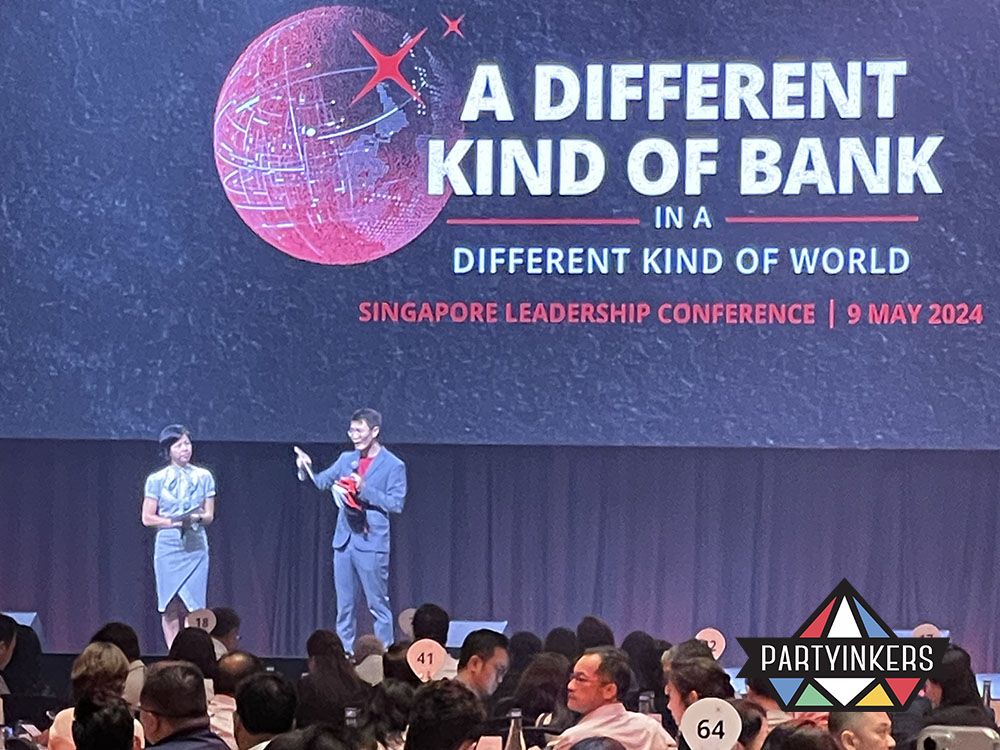 Speakers presenting on stage during a leadership conference, with the backdrop highlighting the event theme.