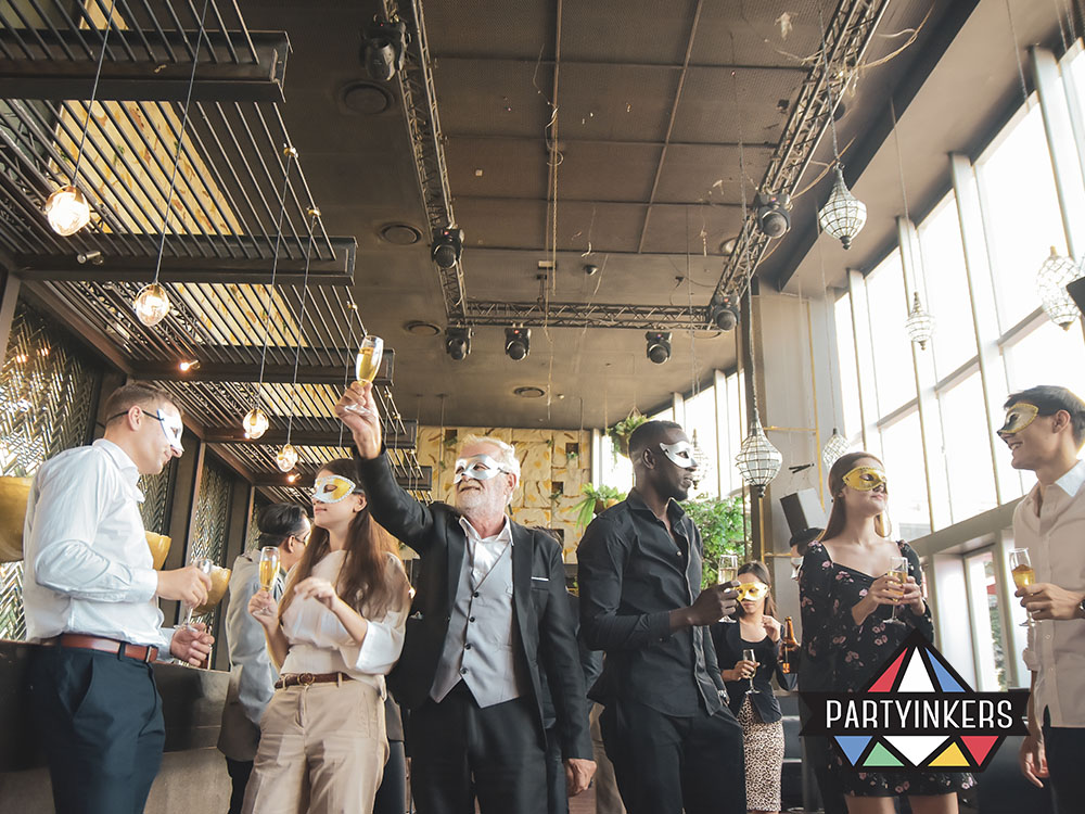 Attendees in elegant masks enjoying drinks at a sophisticated corporate masquerade event.