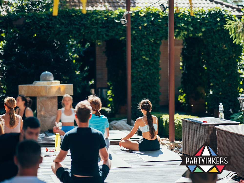 Participants engaging in an outdoor yoga session as part of wellness-focused conference entertainment ideas.