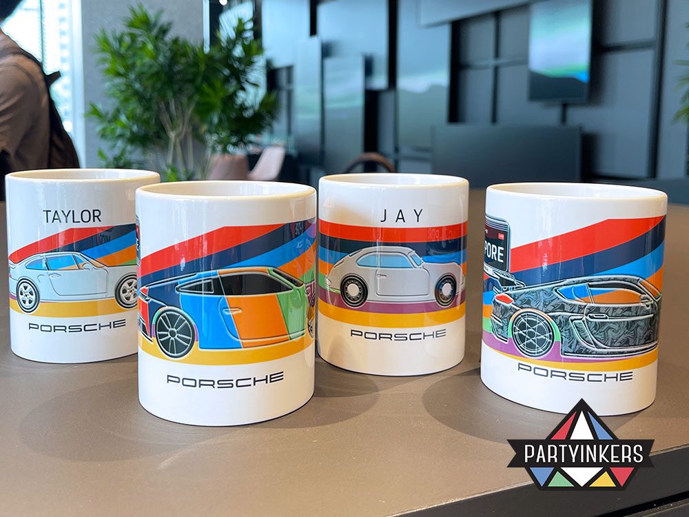 A collection of vibrant, personalized Porsche mugs displayed on a table, each featuring unique car designs and names.