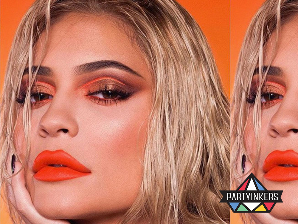 A close-up of a model wearing bold orange makeup, representing brand activation ideas in the beauty industry through striking visual campaigns and influencer marketing.