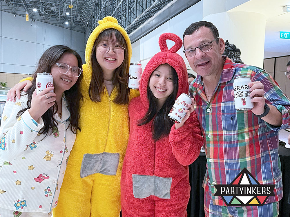 Attendees at a pajama-themed corporate event holding personalized cans, showcasing creative brand activation ideas that enhance audience engagement and brand recall.