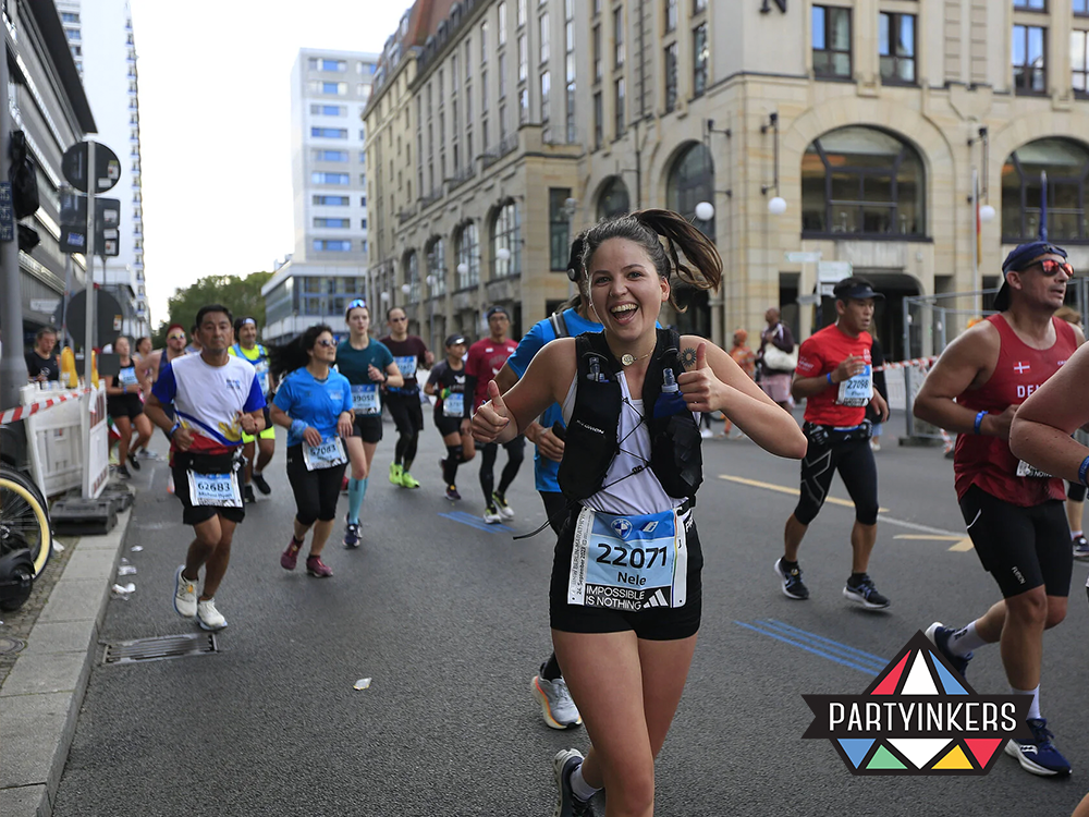 A cheerful runner giving a thumbs-up while participating in a marathon event, showcasing brand activation ideas through sports sponsorships and brand presence at public events.