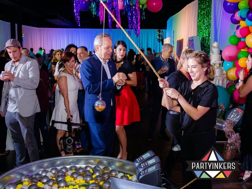 Guests enjoying a fun game at a vibrant annual corporate party with colorful decor and creative staff party ideas.