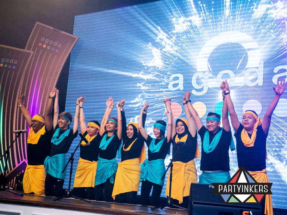 Employees performing a group act on stage during a corporate talent show, one of many creative staff party ideas that highlight unique skills.