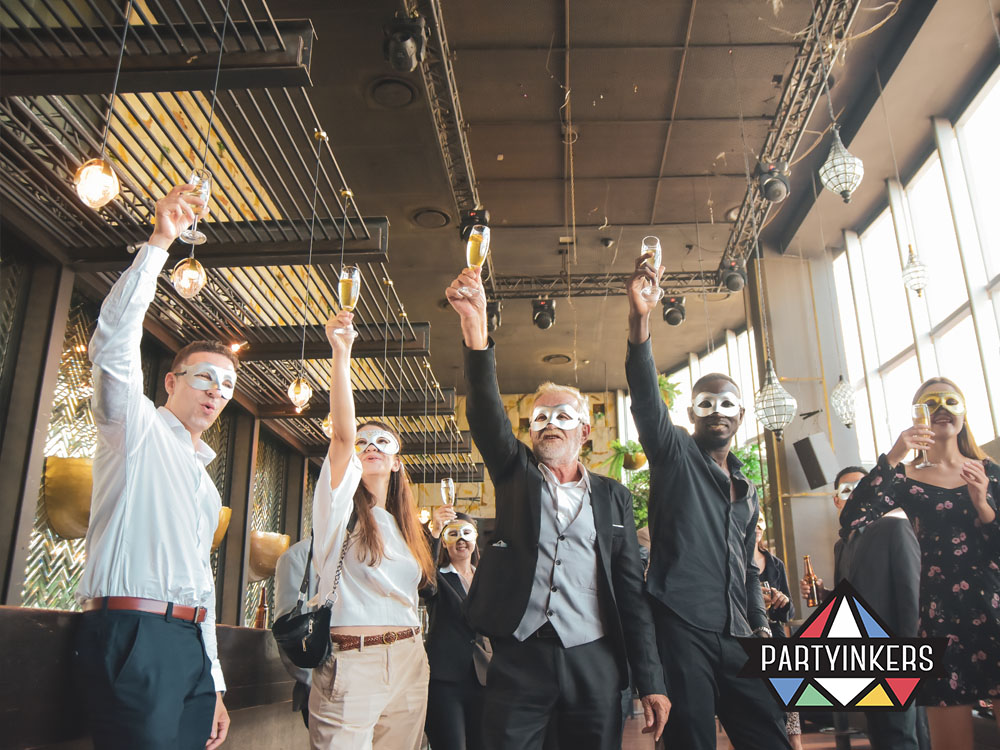 Employees enjoying drinks in elegant masks at a masquerade ball, one of many unique company event themes for corporate entertainment.