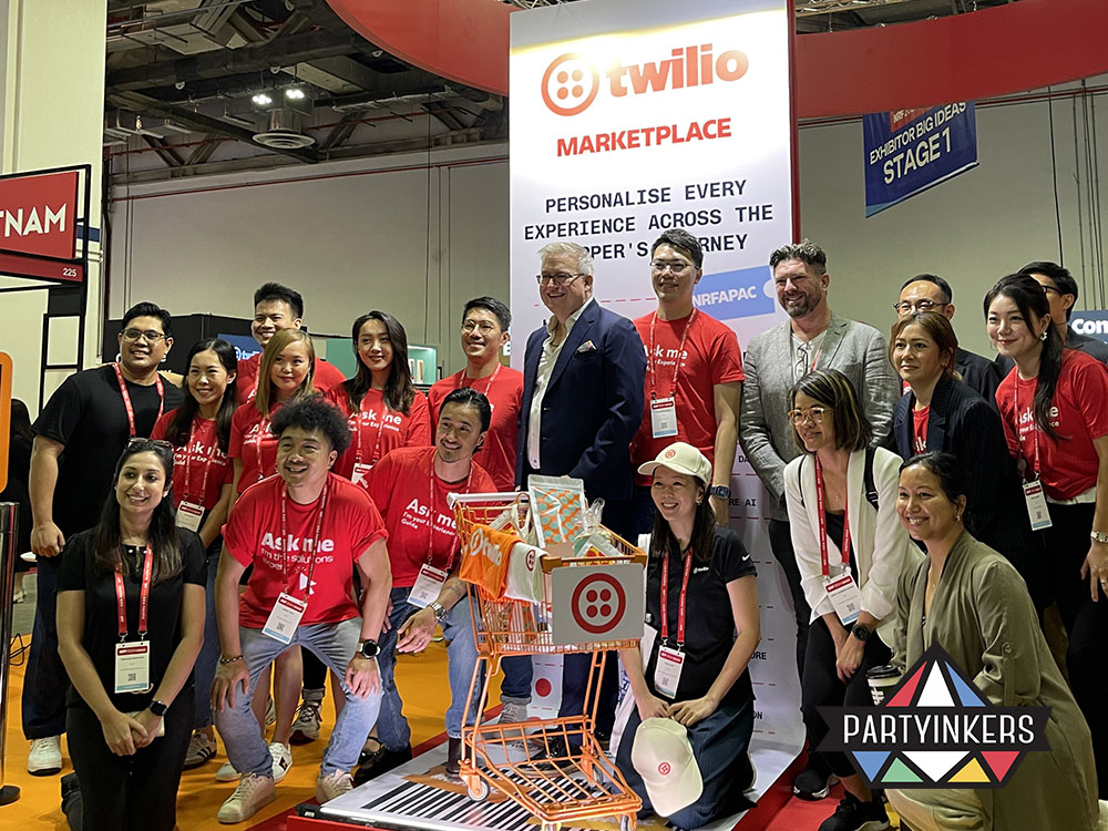 Twilio team at a vibrant booth using branded props and personalization to drive lead capture at trade shows through experiential marketing.